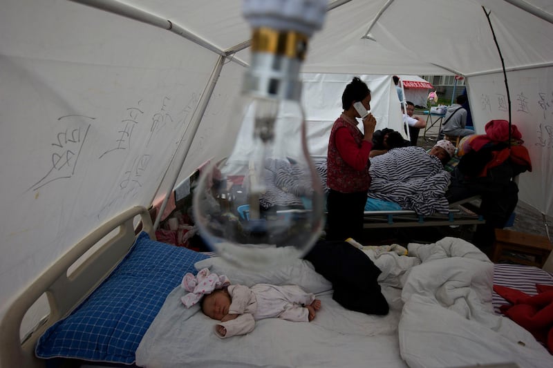 Zhou Xinlong, a three-month-old baby, sleeps at a make shift hospital in the county seat of Lushan in southwestern China's Sichuan province, Sunday, April 21, 2013. Rescuers and relief teams struggled to rush supplies into the rural hills of China's Sichuan province Sunday after the earthquake prompted frightened survivors to spend a night in cars, tents and makeshift shelters. (AP Photo/Ng Han Guan) *** Local Caption ***  China Earthquake.JPEG-053c2.jpg