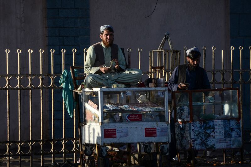 Money changers wait for customers early in the morning of January 19 in Kandahar, Afghanistan. AFP