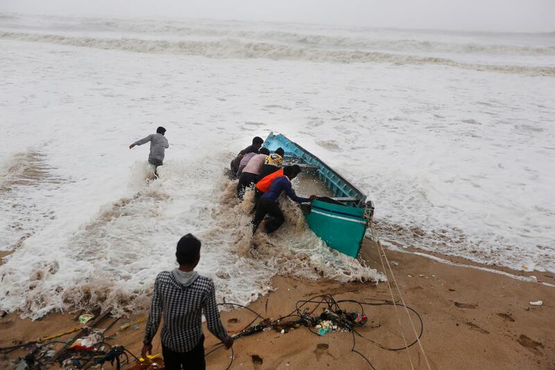 People try to move a fishing boat to a safer ground on the Arabian Sea coast in Veraval, Gujarat, India. AP Photo