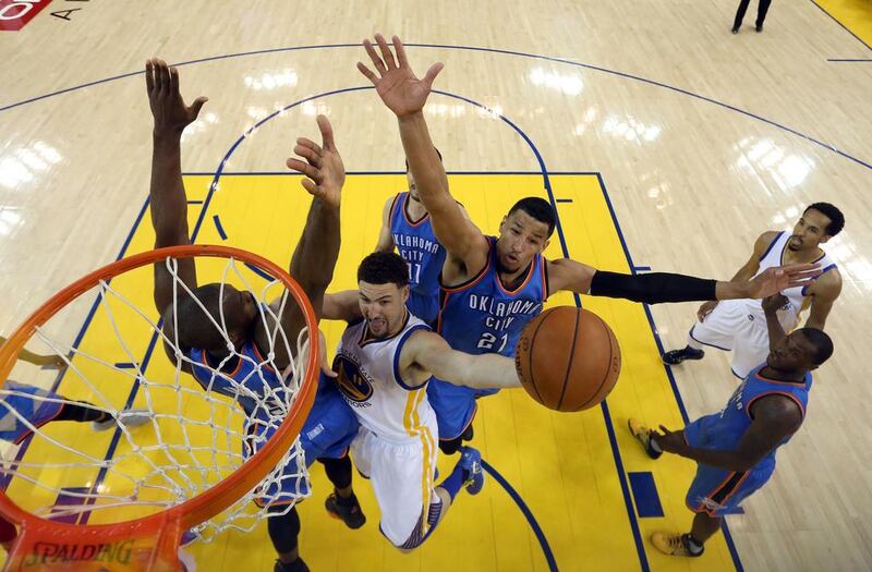 Klay Thompson #11 of the Golden State Warriors goes up for a shot against Serge Ibaka #9 and Andre Roberson #21 of the Oklahoma City Thunder in the first half of Game Seven of the Western Conference Finals during the 2016 NBA Playoffs at ORACLE Arena on May 30, 2016 in Oakland, California. Ezra Shaw/Getty Images/AFP