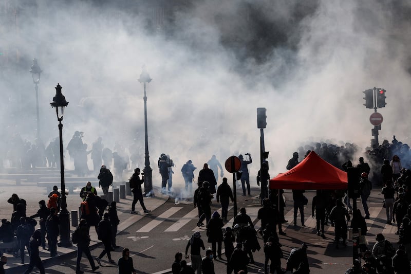 Protesters gather as smoke rises from tear gas during a demonstration in Paris. AFP