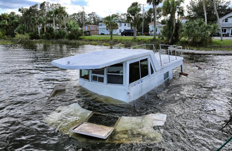 A boat sunk by high winds from Hurricane Matthew sits on the shore of the Halifax River in Ormond Beach, Florida. Joe Burbank / Orlando Sentinel via AP