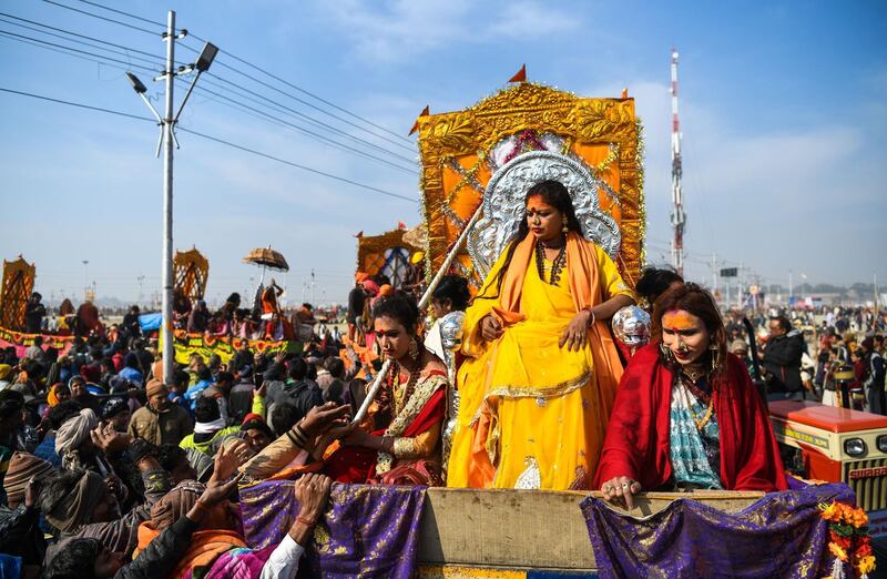 In this photograph taken on January 15, 2019, followers of the Kinnar Akhara monastic Hindu order made up of transgender members ride on a chariot in a procession towards Sangam -- the confluence of the Ganges, Yamuna and mythical Saraswati rivers -- during the auspicious bathing day of Makar Sankranti at the Kumbh Mela in Allahabad. For decades Laxmi Narayan Tripathi has fought untiringly India's conservative laws and beliefs to put her transgender community on a par with the rest of society, and now she has notched up a new milestone. On January 15 she and dozens of other resplendent "Kinnars" splashed in the sacred waters of the Ganga and Yamuna rivers alongside top Hindu ascetics at the immense Kumbh Mela festival in northern India.
 - 
 / AFP / CHANDAN KHANNA
