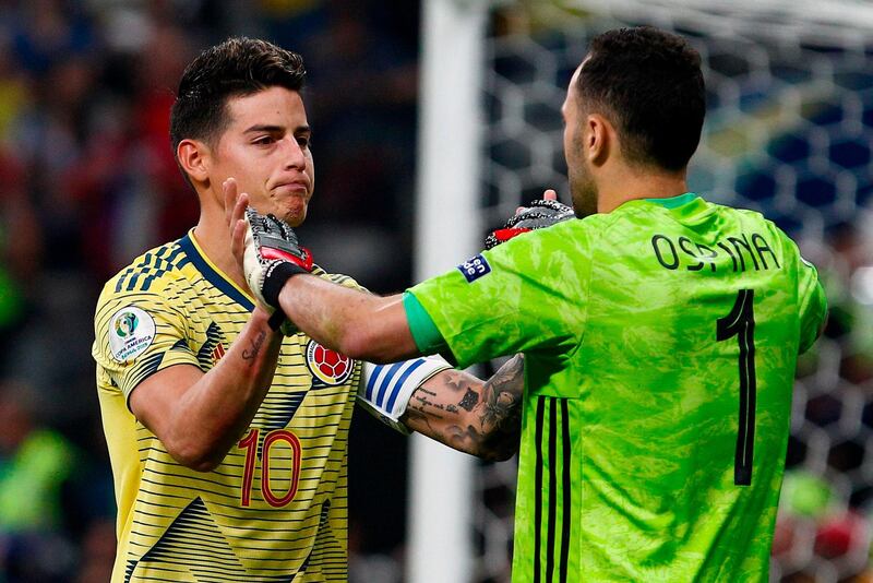 Colombia's James Rodriguez greets goalkeeper David Ospina after scoring his penalty during the penalty shoot-out. AFP