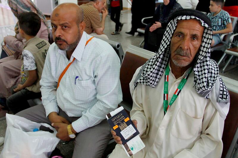 An Iraqi pilgrim shows his passport and ticket to Mecca as he waits for his flight at the airport in Najaf in southern-central Iraq on July 31, 2018, prior to the start of the annual Hajj pilgrimage in the holy city of Makkah. AFP