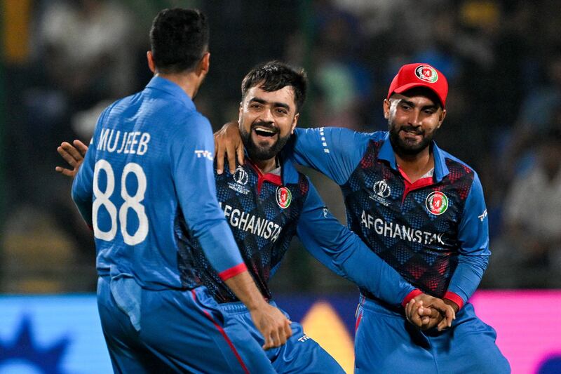 Afghanistan's Rashid Khan celebrates with teammates after taking the wicket of England's Adil Rashid. AFP