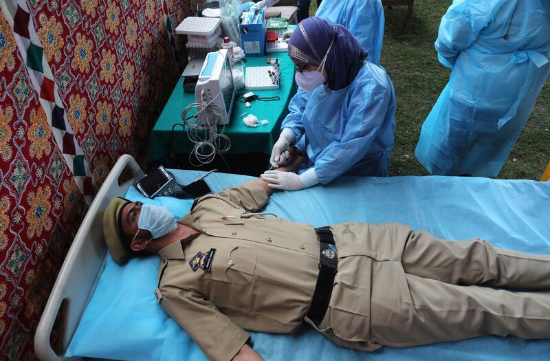 A health worker collects blood samples from a patient recently recovered from Covid-19 in Srinagar, India.  EPA