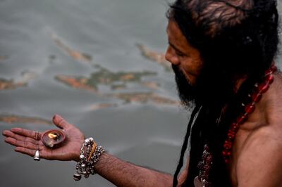 A Sadhu (Hindu holy man) prays on the banks of the Ganges River on the day of Shahi Snan (Royal Bath) during the ongoing religious Kumbh Mela festival, in Haridwar on April 12, 2021. / AFP / Money SHARMA
