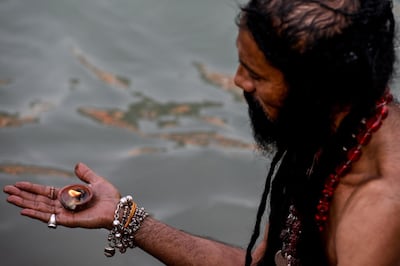 A Sadhu (Hindu holy man) prays on the banks of the Ganges River on the day of Shahi Snan (Royal Bath) during the ongoing religious Kumbh Mela festival, in Haridwar on April 12, 2021. / AFP / Money SHARMA
