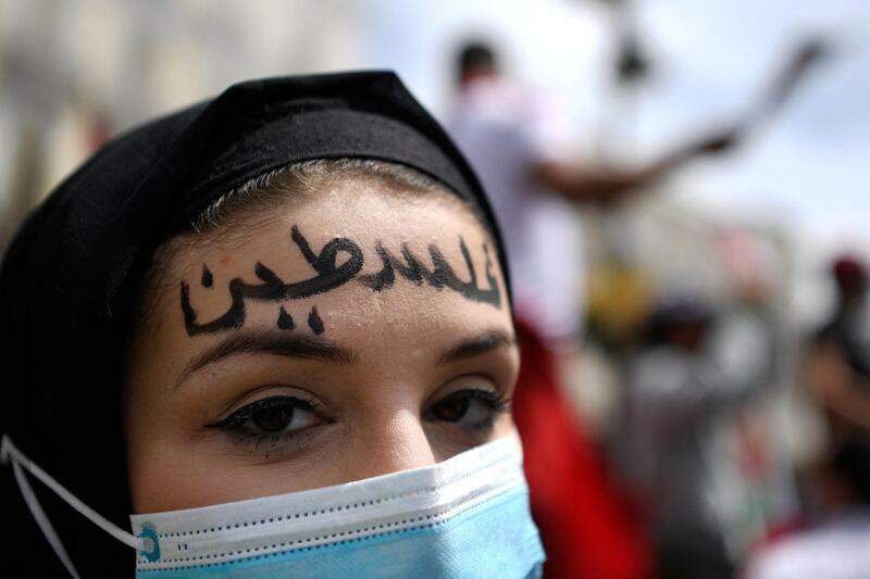 A woman with the word "Palestine" written in Arabic on her forehead takes part in a demonstration marking the 73rd anniversary of the Nakba, which translates as catastrophe, in Madrid. AFP