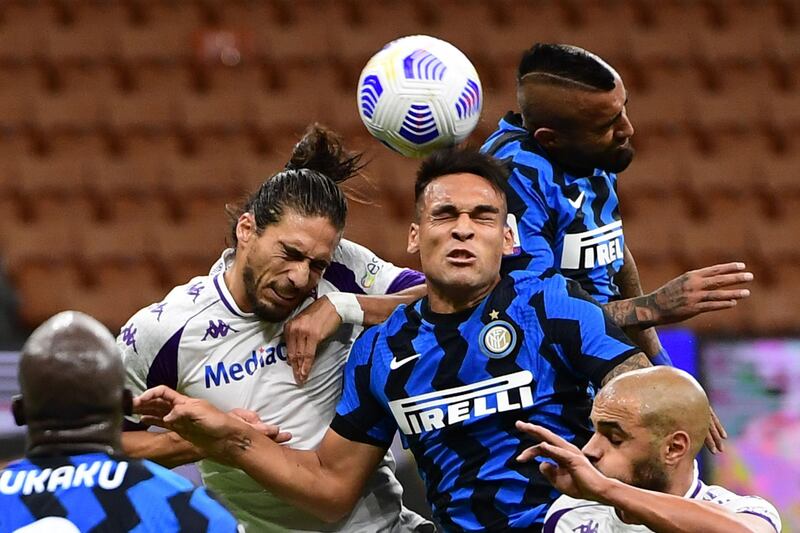 Fiorentina's Martin Caceres, left, challenges Lautaro Martinez and Arturo Vidal, of Inter, for a header in the Serie A clash. AFP