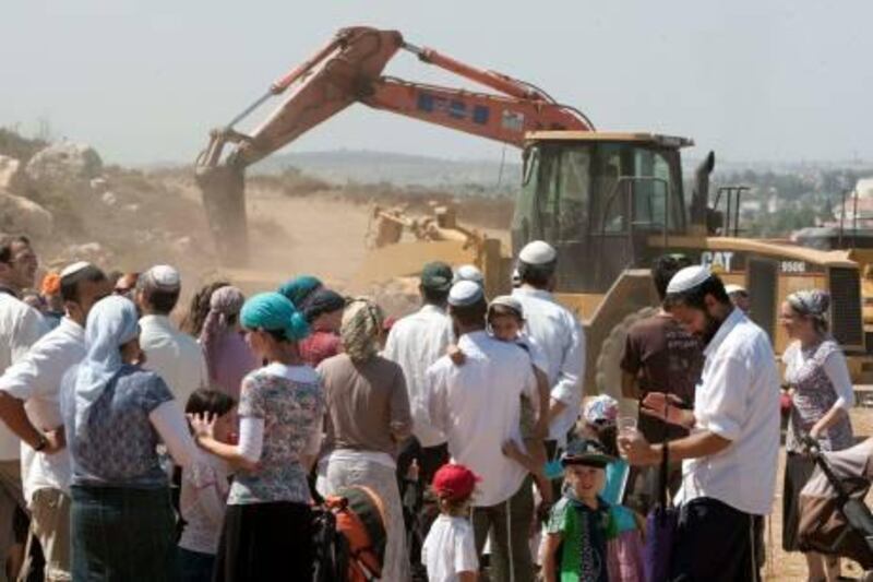 Israeli settlers gather near a tractor on September 27, 2010 at the construction site for 50 housing units in the West Bank settlement of Ariel which will house former residents of the Gush Katif settlements that were dismantled in 2005 in the Gaza Strip. AFP PHOTO/JACK GUEZ

 *** Local Caption ***  276571-01-08.jpg