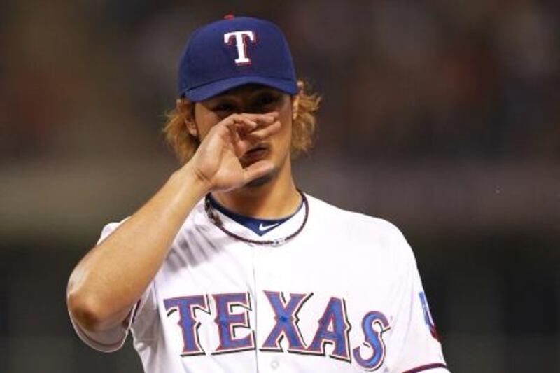 ARLINGTON, TX - APRIL 09: Yu Darvish #11 of the Texas Rangers reacts during play against the Seattle Mariners at Rangers Ballpark in Arlington on April 9, 2012 in Arlington, Texas.   Ronald Martinez/Getty Images/AFP== FOR NEWSPAPERS, INTERNET, TELCOS & TELEVISION USE ONLY ==
 *** Local Caption ***  272295-01-09.jpg