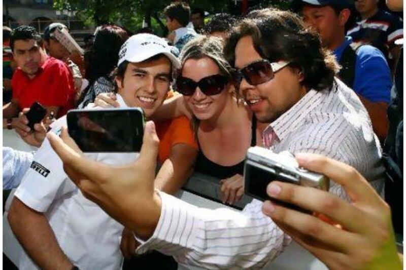 Sergio Perez, left, has not even started a Formula One race, but he is much more in demand by fans of F1. Above he poses for pictures with spectators at an exhibition at Guadalajara in Mexico. Perez makes his debut in Australia on Sunday. David Leah / Mexsport