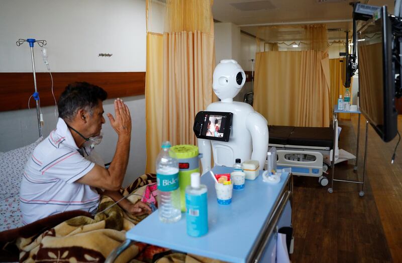 A Covid-19 patient speaks to his family members using a robot named Mitra in the intensive care unit of the Yatharth Super Speciality Hospital in Noida, on the outskirts of New Delhi. Reuters