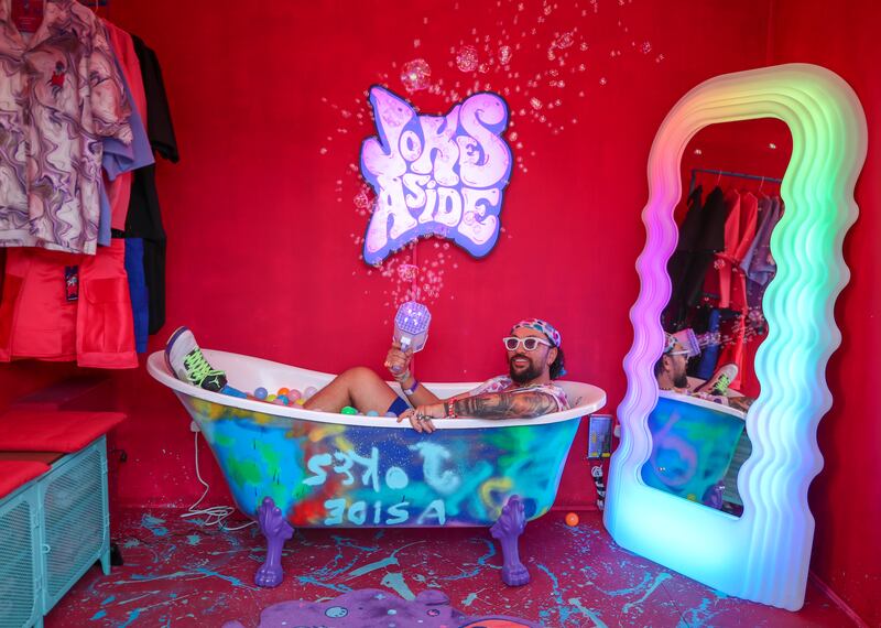 Ibrahim Abudyak poses for a photo in a bathtub of colourful balls 