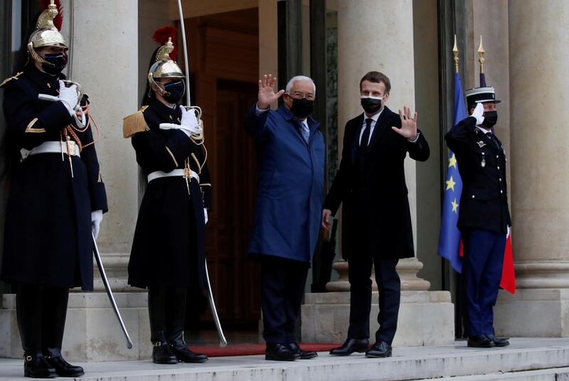 Macron and Portugal's Prime Minister Antonio Costa wave to journalists as they enter the Elysee Palace in Paris, on December 16. Reuters