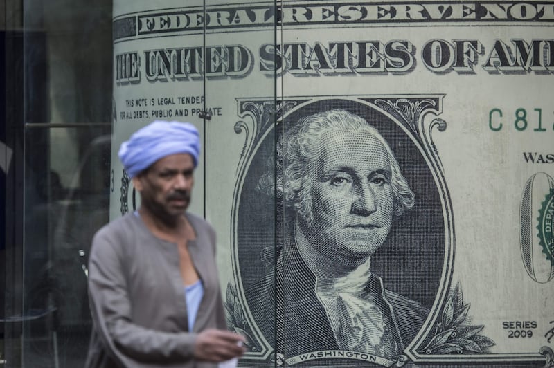A man passes a currency exchange shop in downtown Cairo. AFP