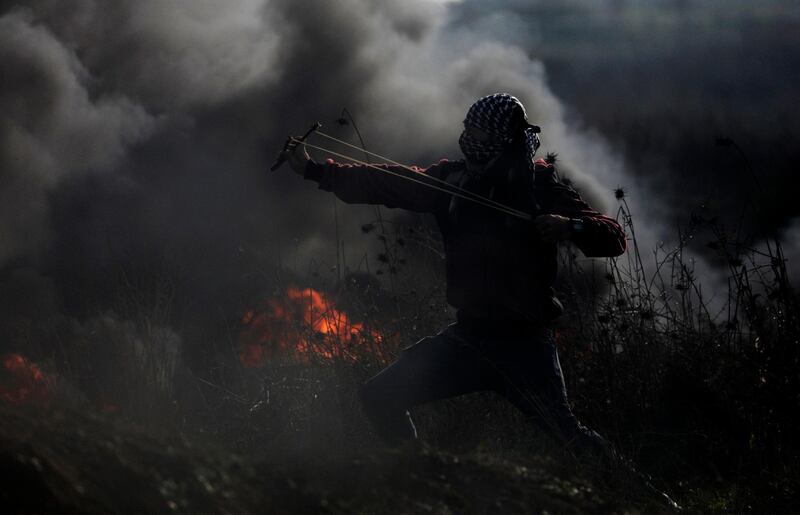 A Palestinian protester throws stones at Israeli troops during clashes with Israeli soldiers amidst a protest organised to show opposition to the US President's decision to recognise Jerusalem as the capital of Israel. Mohammed Saber / EPA