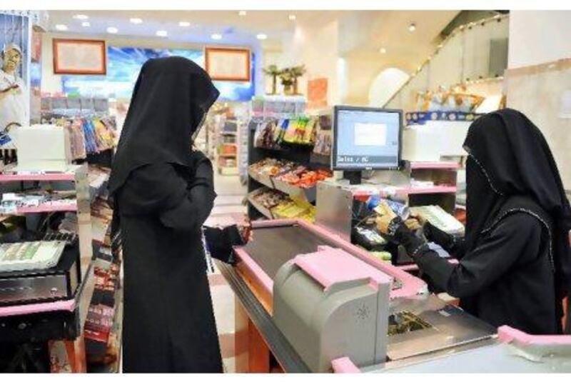 A woman cashier serves a customer at a supermarket in the coastal city of Jeddah, Saudi Arabia.