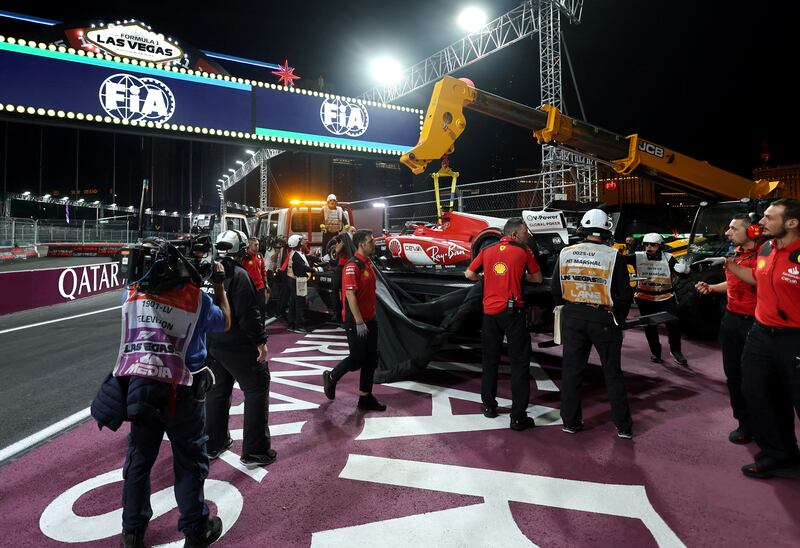 Stewards use a crane to remove the Ferrari of Carlos Sainz. Reuters