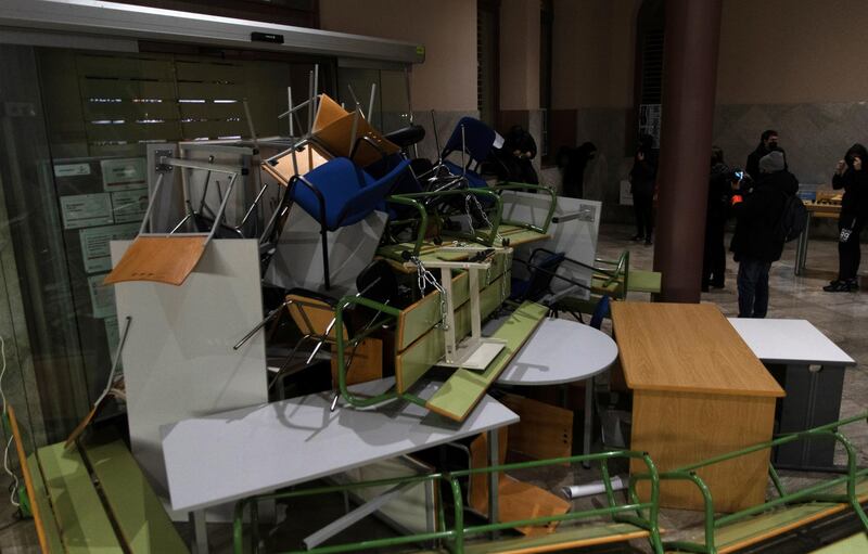 Demonstrators use tables and chairs to set up a barricade against a door. Reuters