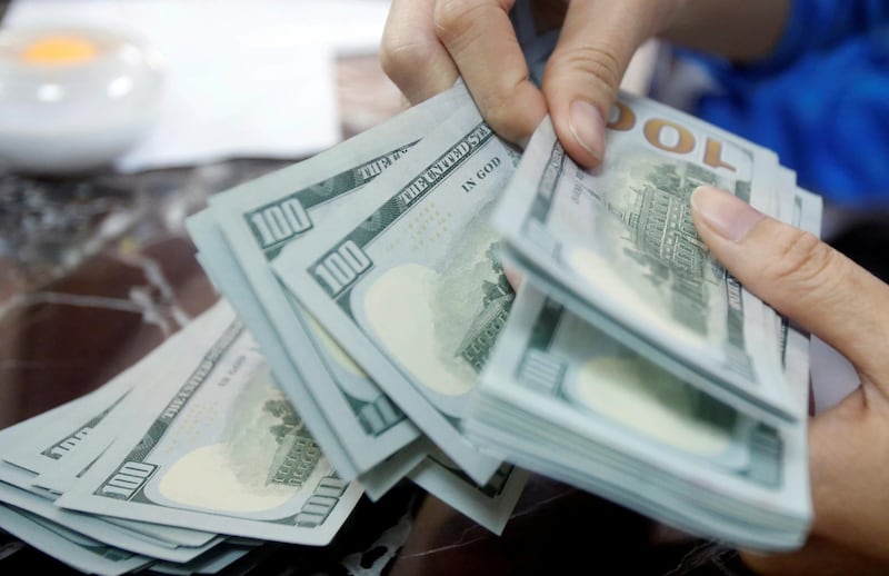 FILE PHOTO: FILE PHOTO: A bank employee counts US dollar notes in this file photo from May 16, 2016. REUTERS/Kham/File Photo