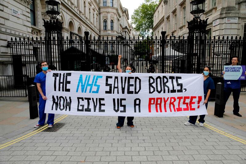 Nurses who work at central London hospitals protest with placards outside Downing Street in central London calling for improved conditions and pay for nursing staff.   AFP