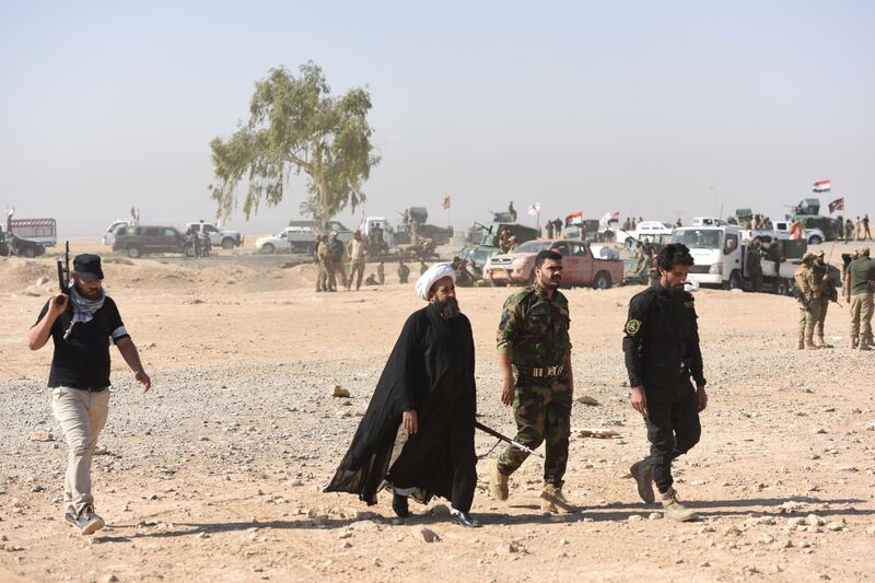 Members of Al-Hashd al-Shaabi faction walk near the frontline on October 21, 2016, near the village of Tall al-Tibah, some 30 kilometres south of Mosul, during an operation to retake the main hub city from the Islamic State (IS) group jihadists. - The al-Hashd al-Shaabi faction is a Popular Mobilisation unit led by Shiite cleric Moqtada al-Sadr that supports the government forces in the battle against the Islamic State (IS) group. (Photo by BULENT KILIC / AFP)