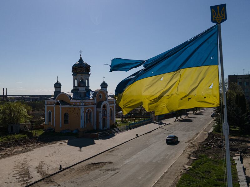 The damaged St Godmothers Cover Church next to a bullet-riddled Ukrainian flag in Malyn, Ukraine. Getty Images