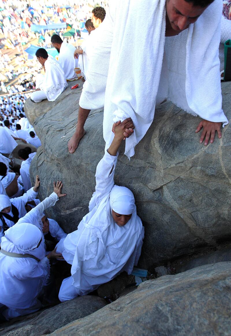 Muslim pilgrims climb a rocky hill called the Mountain of Mercy, on the Plain of Arafat near Mecca, Saudi Arabia, Saturday, Nov. 5, 2011. The annual Islamic pilgrimage draws 2.5 million visitors each year, making it the largest yearly gathering of people in the world. (AP Photo/Hassan Ammar) *** Local Caption ***  Mideast Saudi Arabia Hajj.JPEG-0451d.jpg