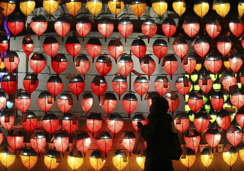 A woman prays in front of lanterns to celebrate the new year at Chogye Buddhist temple in Seoul, South Korea. Ahn Young-joon / AP Photo
