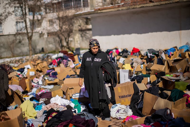 A woman stands amid boxes of donated clothes in Golbasi, Turkey. AP