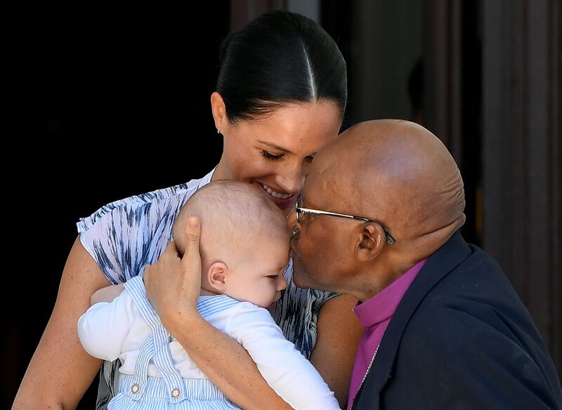 Desmond Tutu kisses Archie Mountbatten-Windsor on the head as he is held by his mother, Meghan, Duchess of Sussex, during a royal tour of South Africa on September 25, 2019. Getty