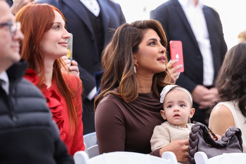 Priyanka Chopra holds her and Nick Jonas' daughter, Malti, as Sophie Turner, Joe Jonas' wife looks on, during the ceremony where the Jonas Brothers will unveil their star on The Hollywood Walk of Fame in Los Angeles, California, U. S. , January 30, 2023.  REUTERS / Mario Anzuoni