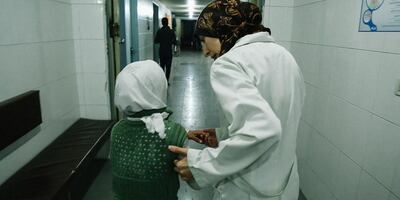 Al Ghouta, Syria - Dr Amani (R) helps a young girl into the hospital. (National Geographic)