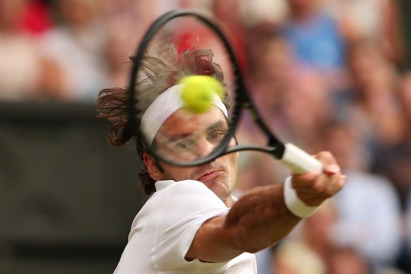 Roger Federer returns to Stan Wawrinka during their singles match on Wednesday at the 2014 Wimbledon Championships quarter-finals. Federer won the match in four sets. Andrew Yates / AFP