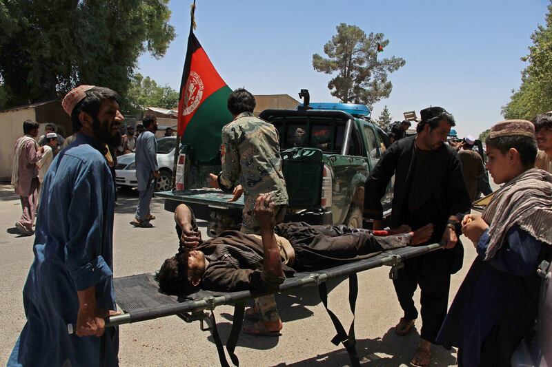 Afghan men carry a victim of a powerful car bomb in Lashkar Gah, the capital of Helmand province, on June 22, 2017. AFP