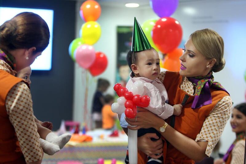 Etihad Airways nanny Slava Pavets shows her skills by entertaining 11-month-old Jariel Neal during the launch of its Etihad Explorers, which will feature Flying Nanny and Etihad Explorer kits for children. Delores Johnson / The National