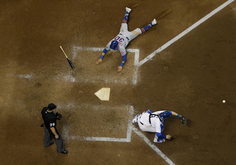 New York Mets' Michael Conforto scores past Milwaukee Brewers catcher Manny Pina during the ninth inning of a baseball game in Milwaukee. Morry Gash / AP Photo