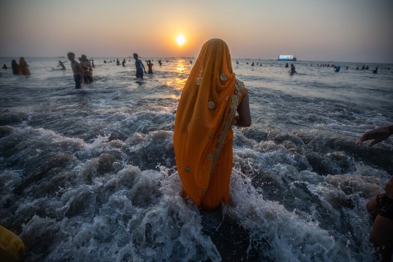 Hindu devotees perform a ritual while offering prayers to the Sun God on the occasion of the Hindu festival 'Chhath Puja', at Juhu beach, in Mumbai, India.  Chhath Puja is an ancient Hindu festival dedicated to Surya, the Hindu Sun God, also known as Surya Shashti.  The Sun, considered the god of energy and the life force, is worshiped during the Chhath festival to promote well-being, prosperity, and progress. EPA
