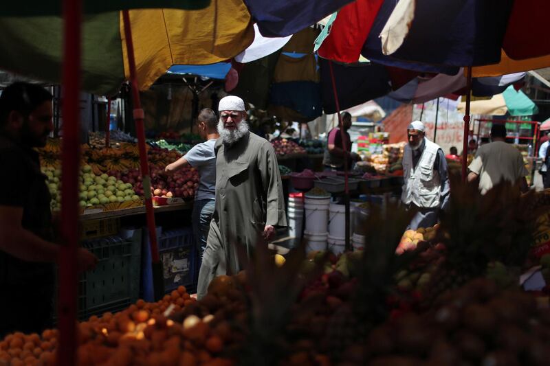Palestinian shoppers walk in a market in Khan Younis refugee camp in the southern Gaza Strip.  Reuters