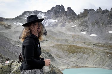 A woman takes part in a ceremony to mark the 'death' of the Pizol glacier (Pizolgletscher) on September 22, 2019 above Mels, eastern Switzerland. In a study earlier this year, researchers of ETH technical university in Zurich determined that more than 90 percent of Alpine glaciers will disappear by 2100 if greenhouse gas emissions are left unchecked. / AFP / Fabrice COFFRINI