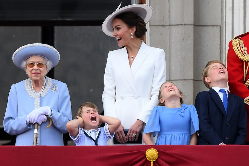Prince Louis holds his ears as he stands next to Queen Elizabeth, his mother Catherine, Duchess of Cambridge, Princess Charlotte and Prince George to watch a special flypast from the Buckingham Palace balcony. AFP