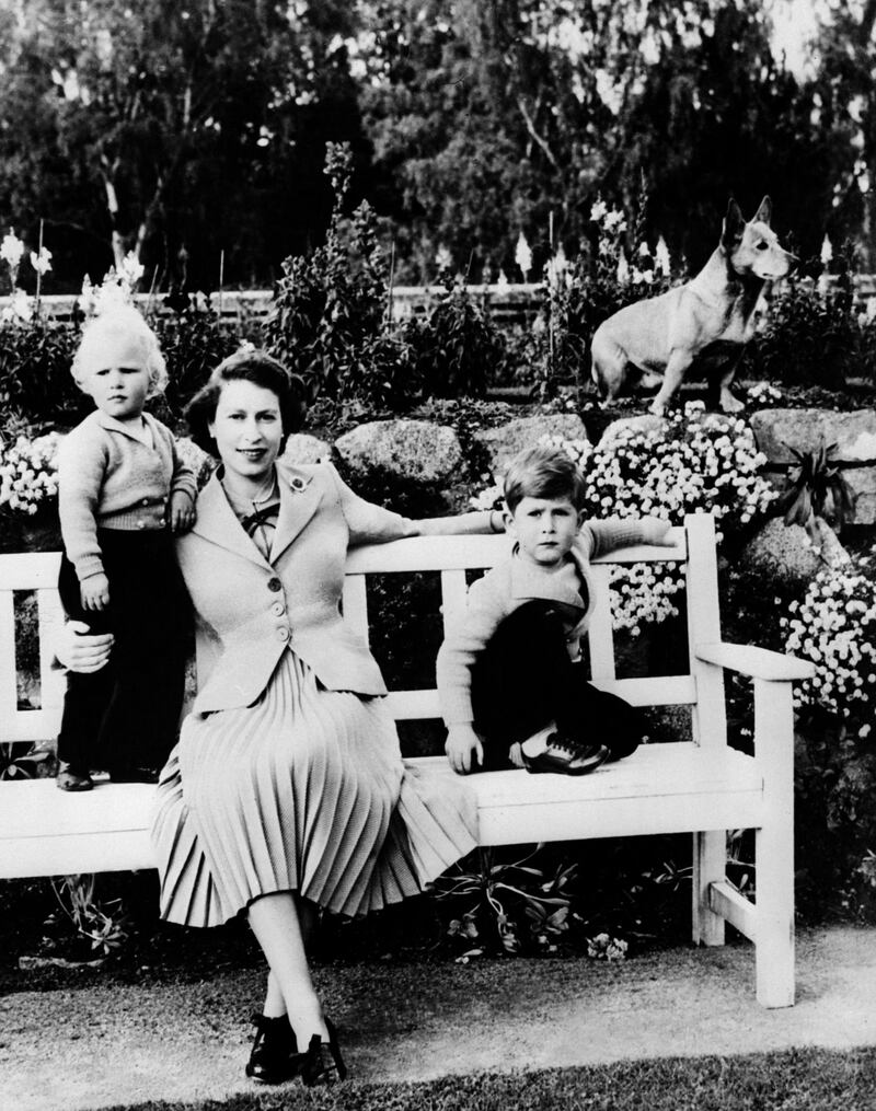 The queen and her two children Charles, right, and Anne, left, alongside their pet corgi in Balmoral in 1954. AFP