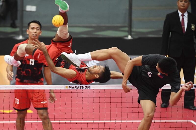 Indonesia's Syaiful Rijal competes with Regie Reznan Fabriga of the Philippines (R) during their men's team doubles preliminary round robin sepak takraw match at the 29th Southeast Asian Games (SEA Games) in Kuala Lumpur. Adek Berry / AFP