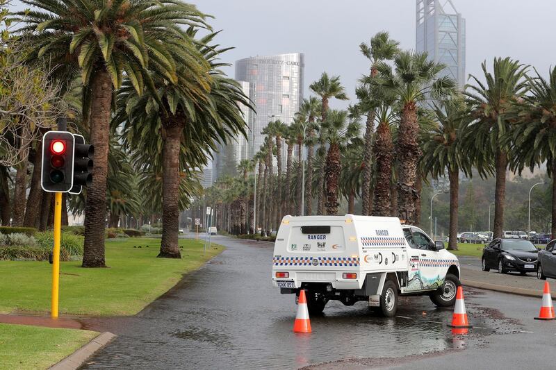 A police vehicle blocks part of Riverside Drive near the Swan River, which is partially closed due to storm flooding, in Perth, Western Australia.  EPA