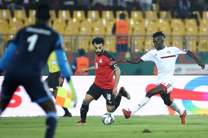 Egypt forward Mohamed Salah runs with the ball under pressure from Sudan's defender Mazin Mohamedein Alnour Mohamed. AFP