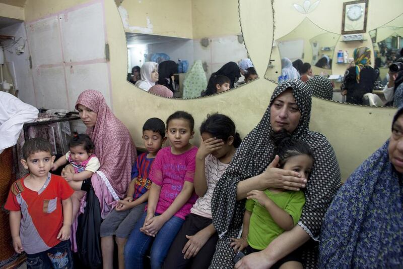 Women and children take shelter in a hair dresser shop after the Al Jazeera office was hit by several Israeli rockets in Gaza City July 22,2014. Heidi Levine for The National