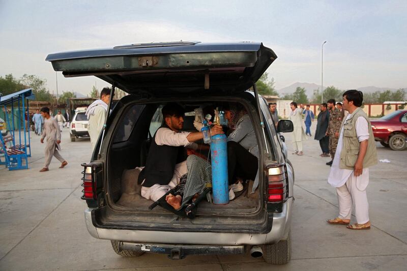 An injured man is brought in a car to a hospital following a blast outside a school in the west Kabul district of Dasht-e-Barchi, that killed at least 50 people and wounded scores more including students, officials said. AFP